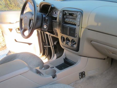 1991 Ford LTD Crown Victoria - The interior of a vehicle shows the dashboard, steering wheel, and center console with cup holders.