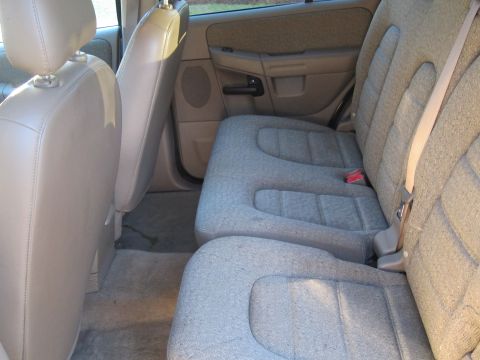1991 Ford LTD Crown Victoria - The interior of a light-colored SUV shows the rear seating area with fabric upholstery and beige trim.