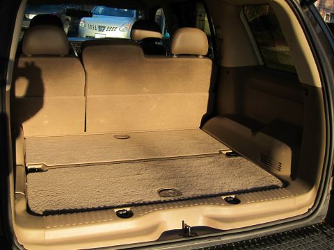 1991 Ford LTD Crown Victoria - The cargo area of an SUV is shown, with seats folded down. Another vehicle is visible outside.