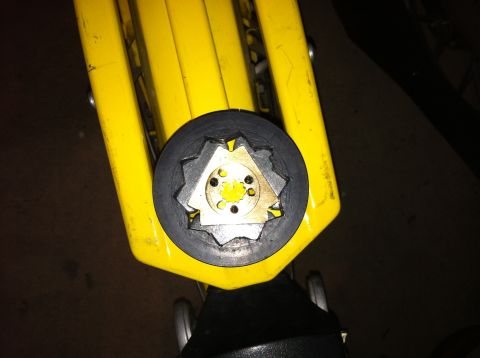 1981 Garelli Rally Sport - Detail of a yellow jack's lifting mechanism, a star-shaped metal part within a rubber boot.