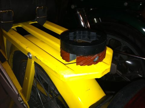 1981 Garelli Rally Sport - A black and brown clutch part sits on the yellow rear rack of a moped.