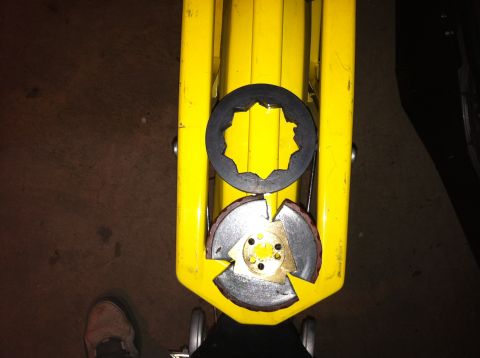 1981 Garelli Rally Sport - Close-up of clutch assembly components on a yellow jack, with a person's shoe visible in the lower left.