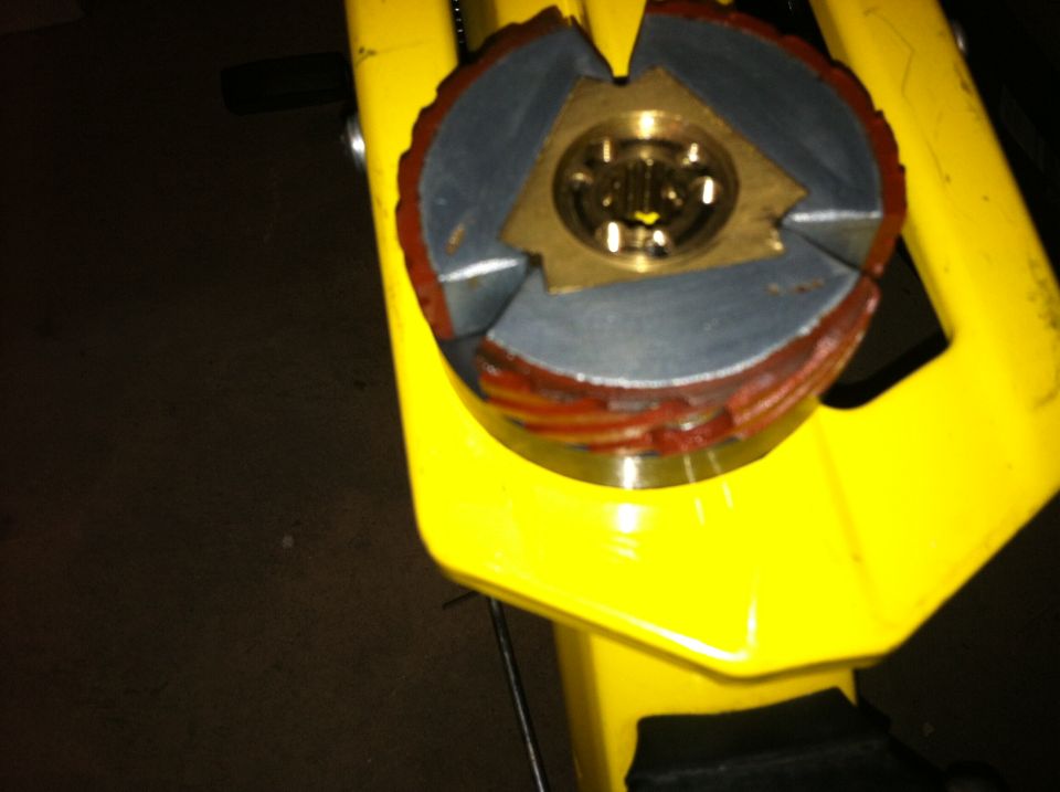 Clutch assembly with red and gray friction material, mounted on yellow metal