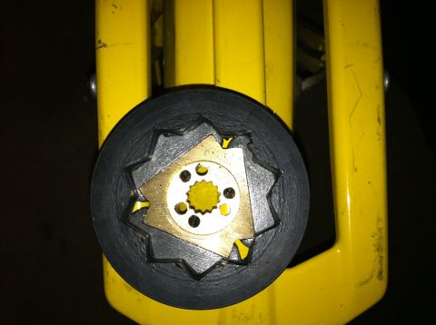 1981 Garelli Rally Sport - Close-up of a clutch part with a black outer ring and gold inner mechanism, set against a yellow background.