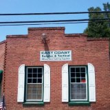 1992 Ford Mustang - A brick building facade features a sign for 'EAST COAST Angler & Tactical' above two windows with shutters.