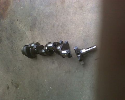 1986 Ford Bronco - A crankshaft, a critical engine component, is shown on a textured surface.