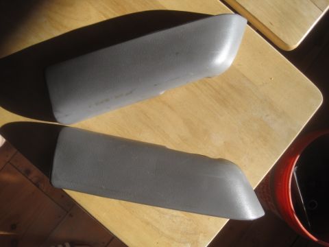 1993 Ford Bronco - Two gray plastic door panel armrests are shown on a wooden surface.