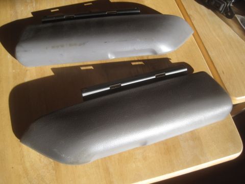 1993 Ford Bronco - Two vehicle armrest pads are shown on a wooden table.