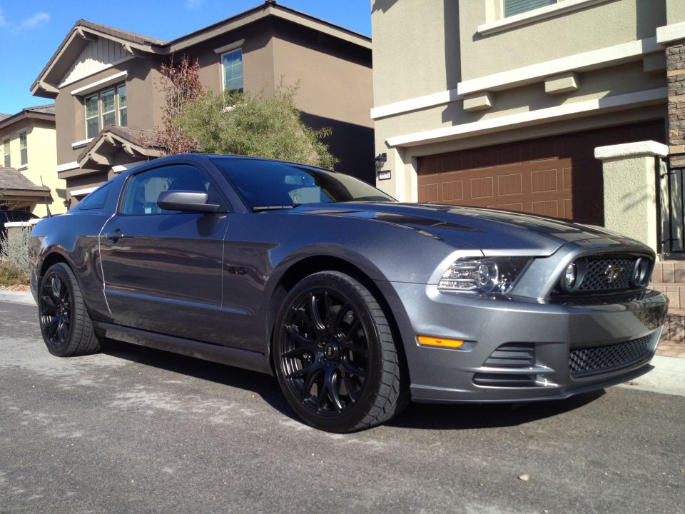 Gray Ford Mustang with black rims parked in a driveway