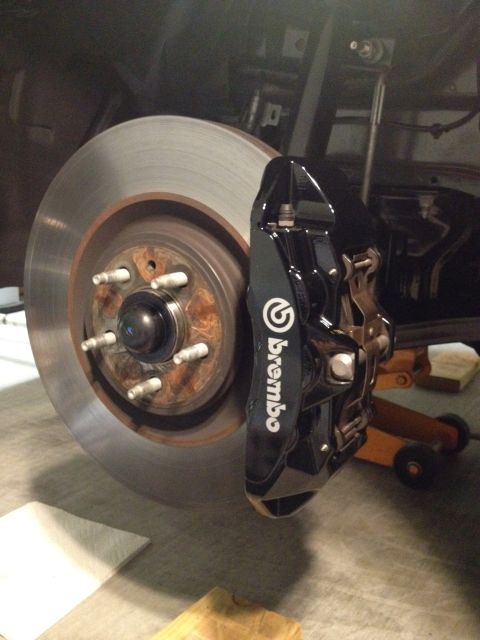 2013 Ford Mustang - A close-up view of a black Brembo brake caliper and rotor, indicating performance upgrades.