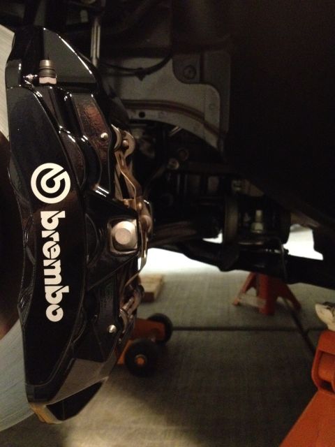 2013 Ford Mustang - Close-up of a Brembo brake caliper, indicating performance upgrades.