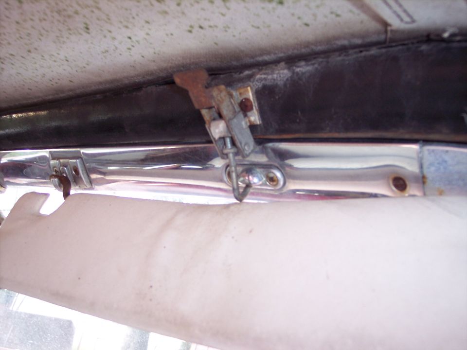 Close-up of a car's interior latch mechanism above a sun visor