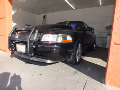 2003 Ford Crown Victoria - Front view of black sedan fitted with brush guard push bar, California license plate visible