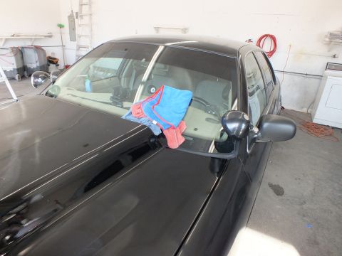 2003 Ford Crown Victoria - Windshield and gray mirror of black sedan with microfiber towels draped on the glass