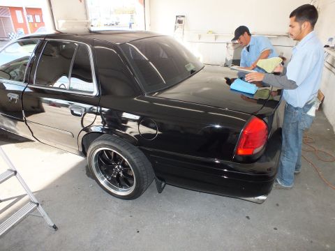 2003 Ford Crown Victoria - Lowered black Crown Victoria on black five-spoke wheels sits in an open detail bay.