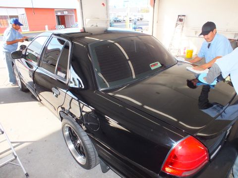 2003 Ford Crown Victoria - Lowered black Crown Victoria rear shown with tinted glass and dark aftermarket wheels.