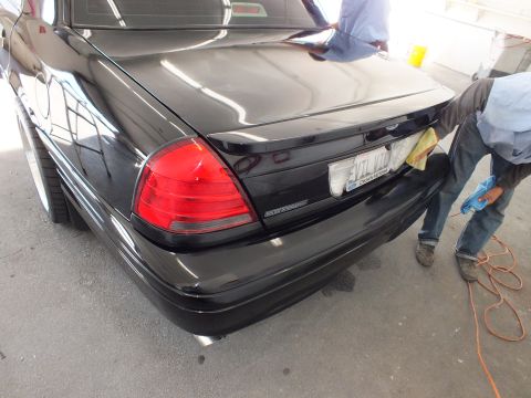 2003 Ford Crown Victoria - Close rear view of a black Crown Victoria showing taillight, bumper and trunk badge.