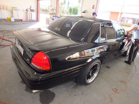 2003 Ford Crown Victoria - Lowered black Crown Victoria on dark wheels gets rinsed in an open detailing bay.