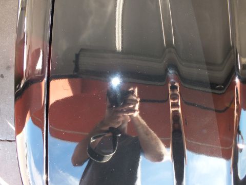2003 Ford Crown Victoria - Photographer reflection mirrored in the glossy black hood of a freshly detailed sedan.