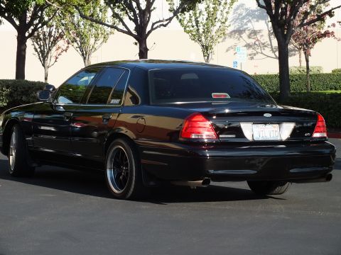 2003 Ford Crown Victoria - Rear three-quarter of a black full-size sedan with dark wheels in a lot