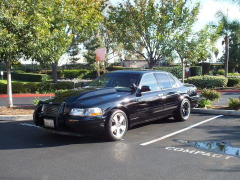 2003 Ford Crown Victoria - Front quarter of a black full-size sedan in a compact parking stall