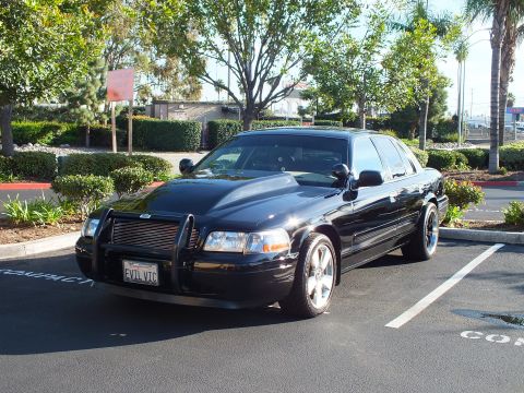 2003 Ford Crown Victoria - Front three-quarter of a black full-size sedan parked near palm trees
