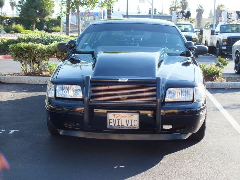 2003 Ford Crown Victoria - Head-on shot of a black sedan with push bar; plate frame reads Crown Victoria