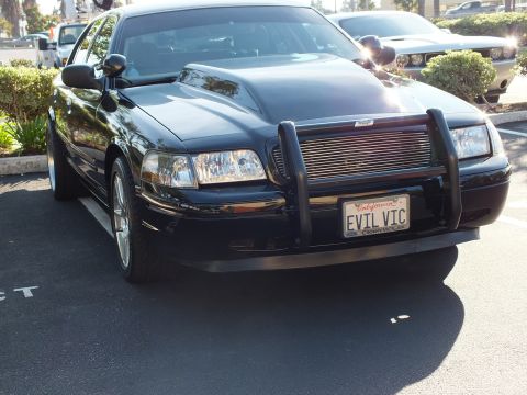 2003 Ford Crown Victoria - Front three-quarter of a black full-size sedan with billet grille outdoors
