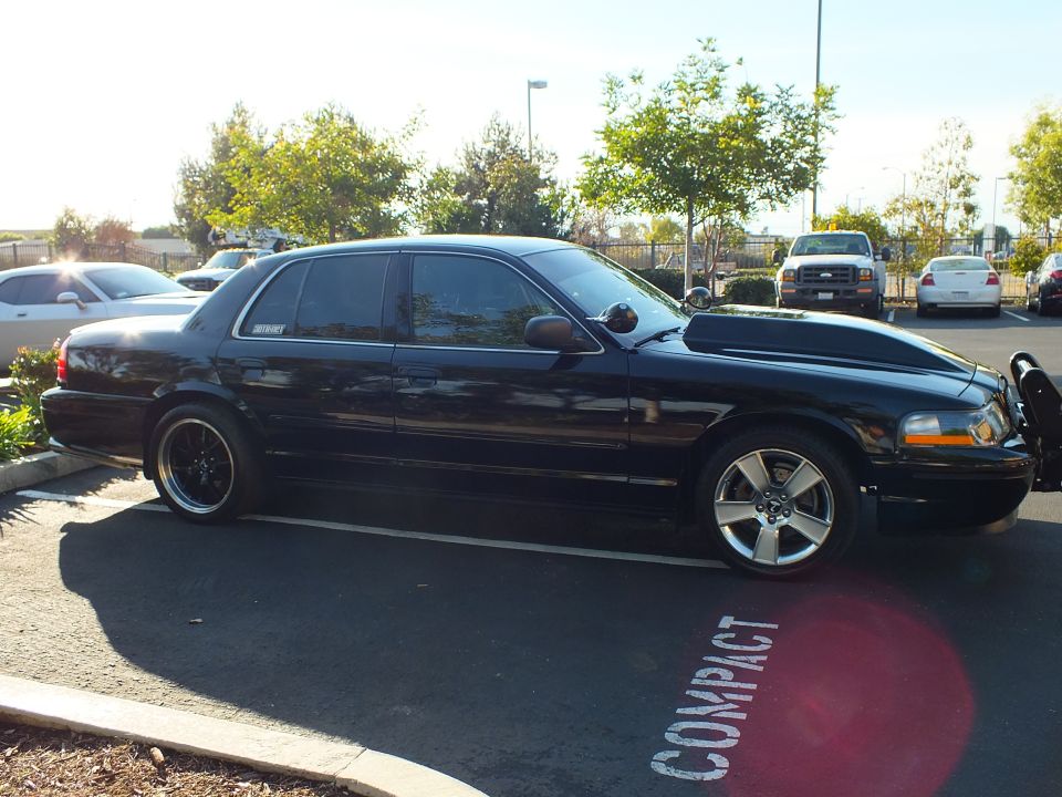 Driver side of black Mercury sedan with MERCURY window decal and machined-lip wheels