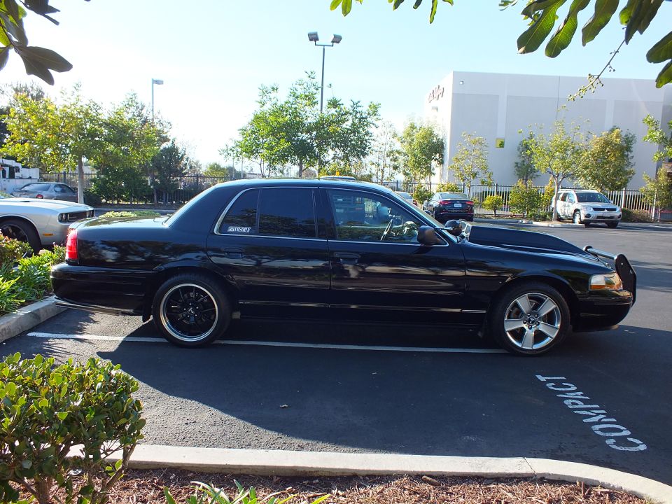 Passenger side profile of black Mercury sedan lowered on black machined-lip wheels