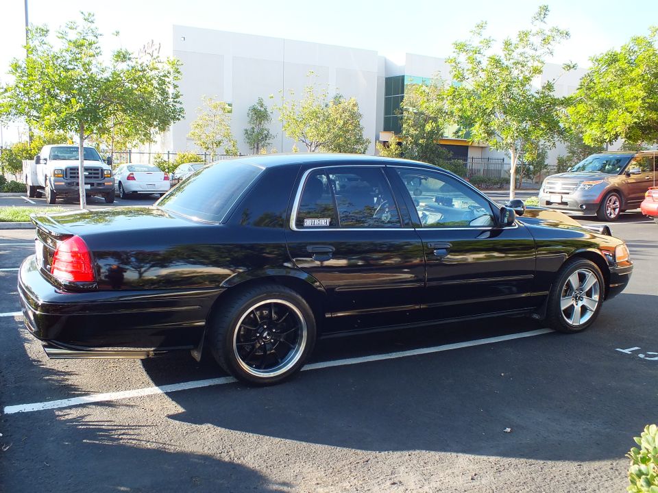 Driver rear quarter of black Mercury sedan with MERCURY decal lowered on black wheels
