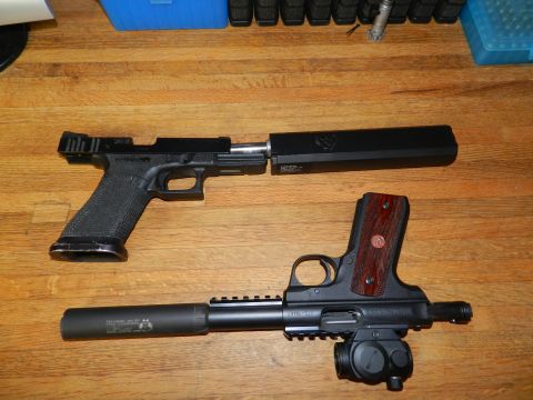 1996 Ford Bronco - Two handguns, a Glock and a Ruger, are shown with suppressors attached on a wooden surface.