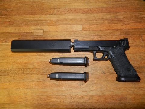1996 Ford Bronco - A handgun with a silencer and two spare magazines are displayed on a wooden table.
