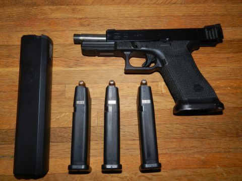 1996 Ford Bronco - Pistol with multiple magazines laid out on a wooden table.