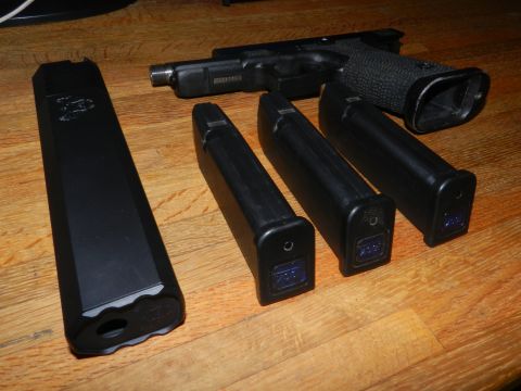 1996 Ford Bronco - A handgun and its magazines are laid out on a wooden table.