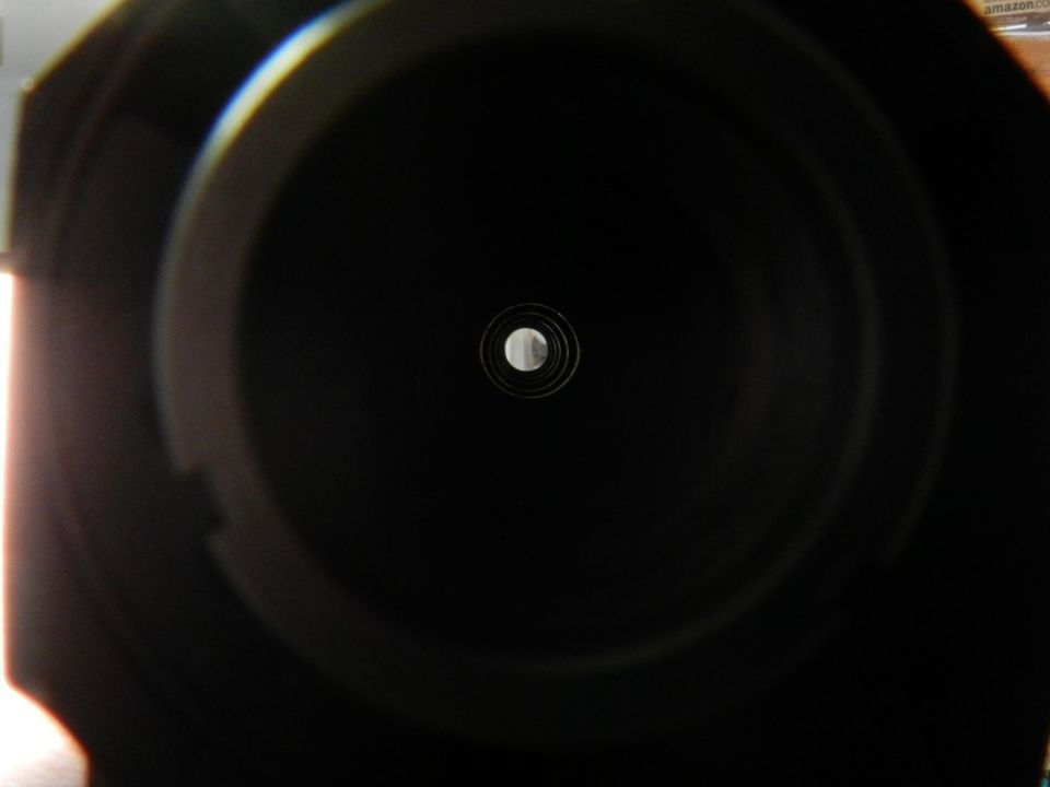 Camera lens aperture with concentric rings and a central opening, dark interior