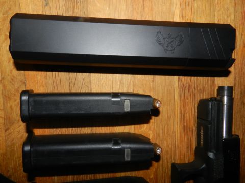 1996 Ford Bronco - Pistol slide and magazines displayed on a wooden surface, with a website logo at the bottom.