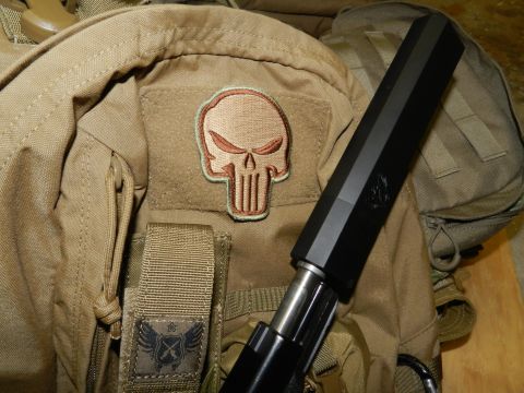 1996 Ford Bronco - A tactical backpack displays a Punisher skull patch and a firearm suppressor, with a website logo visible at the bottom.