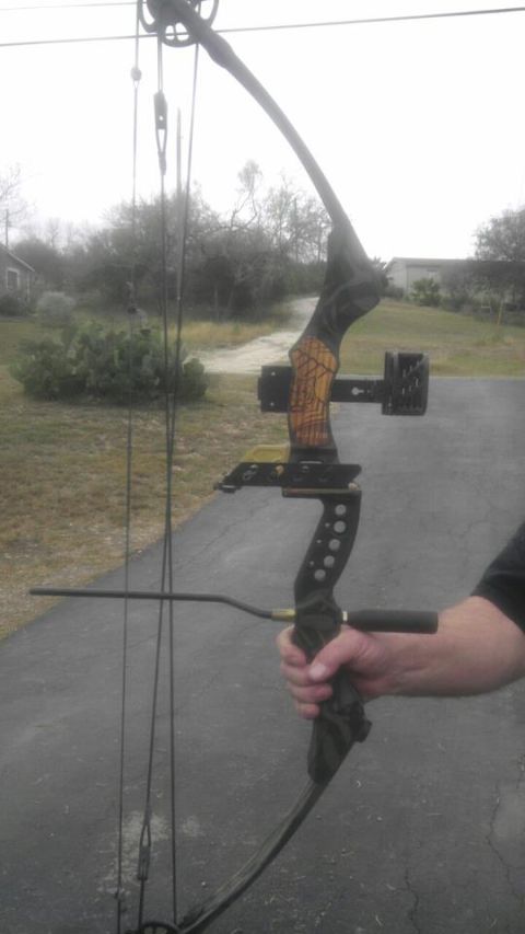 1989 Ford Bronco - A compound bow is held in a person's hand against an outdoor backdrop.