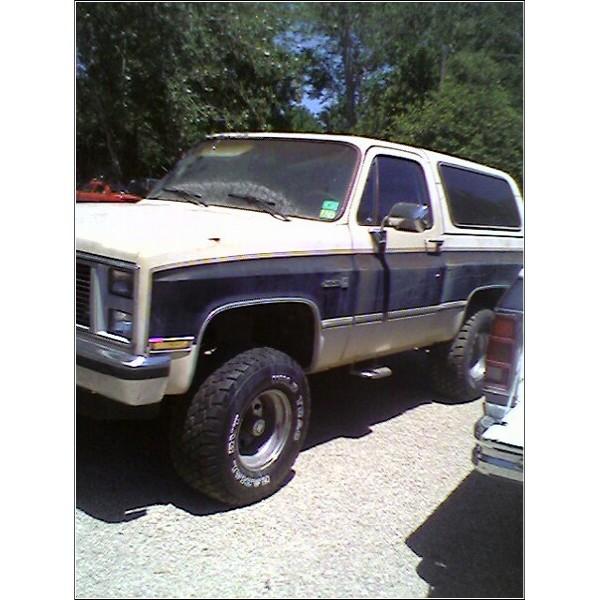 Two-tone SUV with dark blue and tan body panels, lifted suspension, and off-road tires