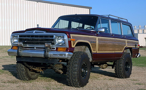 1989 Ford Bronco - This lifted SUV features classic wood paneling and prominent off-road tires, suggesting a model from the late 1980s.