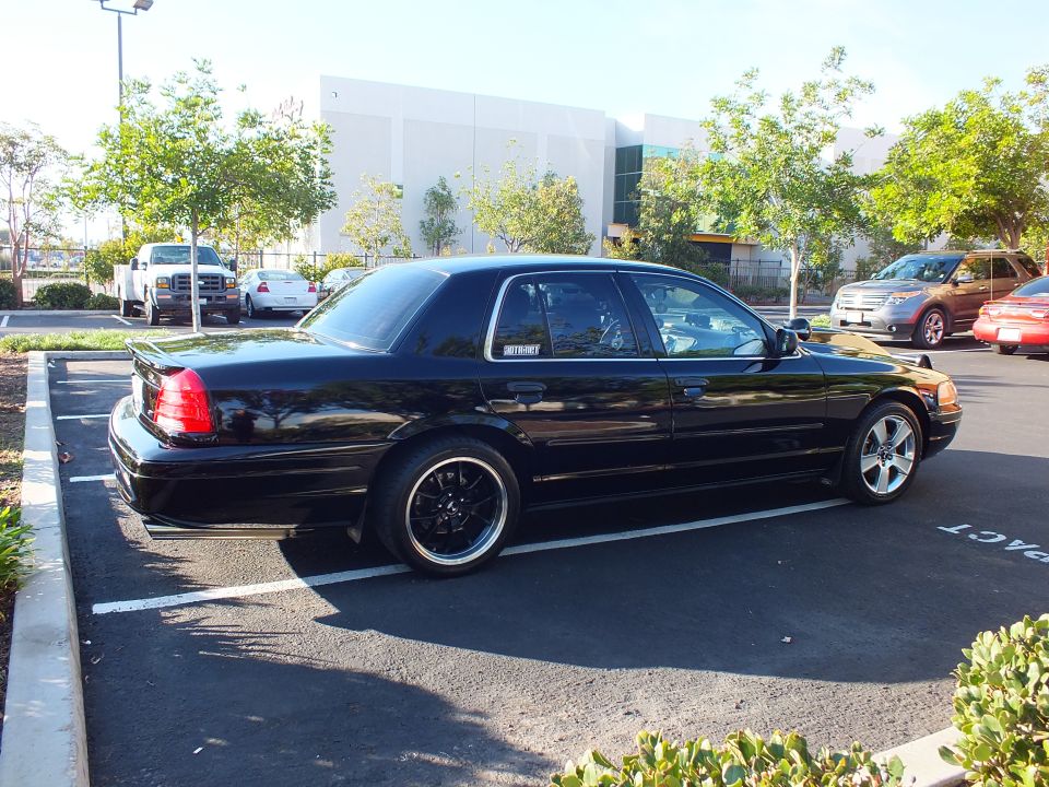 Driver rear quarter of black Mercury sedan with MERCURY decal lowered on machined wheels