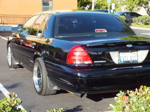2003 Ford Crown Victoria - Rear-left view of a black Crown Victoria, taillights and California plate in frame.