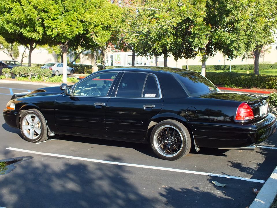 Black Ford Crown Victoria full driver-side profile in parking space