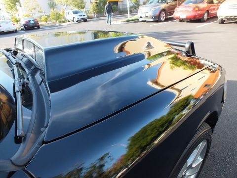 2003 Ford Crown Victoria - Raised hood detail of a black sedan showing a center vent and wiper cowl.