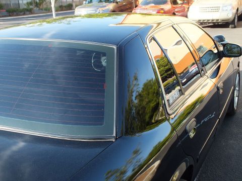 2003 Ford Crown Victoria - Roof, rear glass and C-pillar of a black sedan seen from a high side angle.
