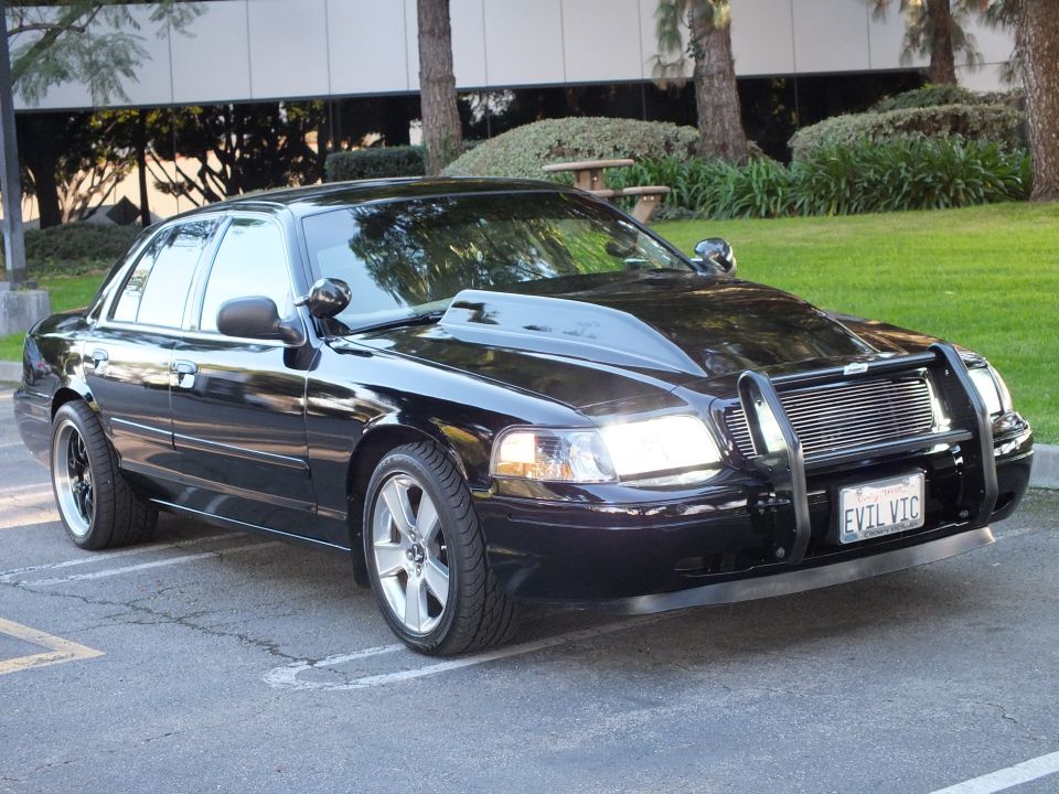 Black Ford Crown Victoria front quarter, headlights on, billet grille, plate EVIL VIC