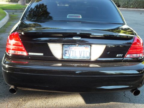 2003 Ford Crown Victoria - Black Crown Victoria rear with California EVIL VIC plate, model frame, and twin angled tailpipes.