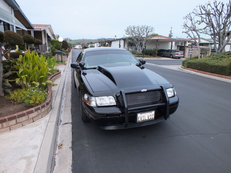 Black Ford Crown Victoria with chrome push bumper grille guard, front view, EVIL VIC plate