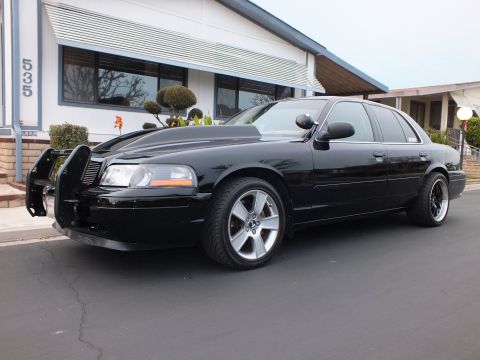 2003 Ford Crown Victoria - Front-quarter view of a lowered black Crown Victoria with grille guard outside a home marked 535.